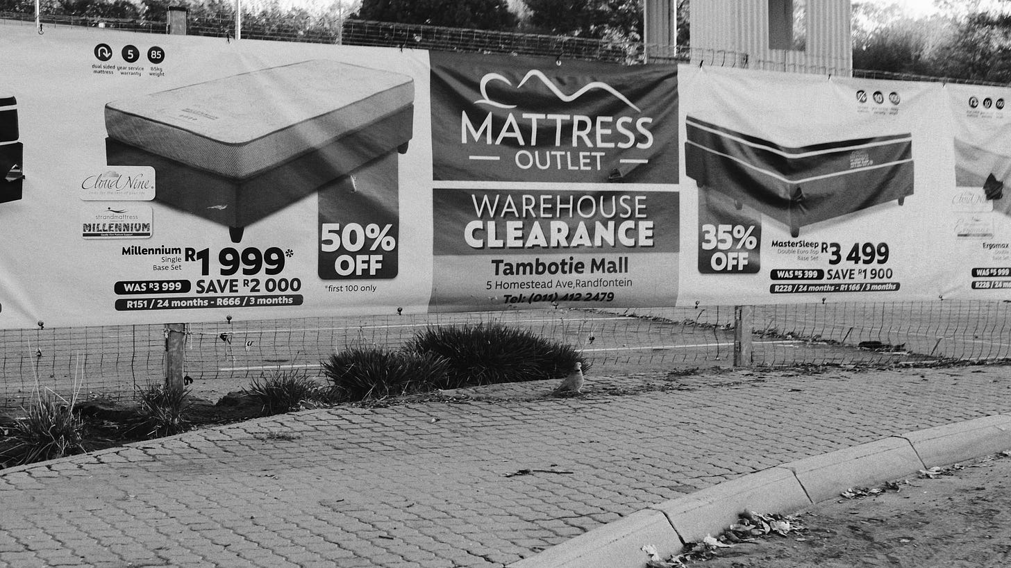 A photo of advertisements against a fence in Gauteng. A photo of advertisements against a fence in Gauteng.