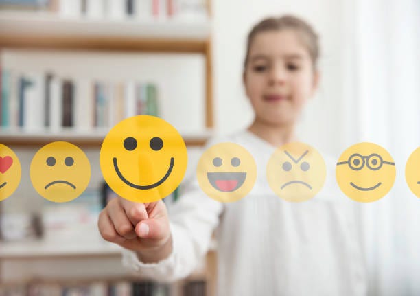 petite fille en touchant l’icône emoji de smiley sur l’écran tactile - personifications photos et images de collection