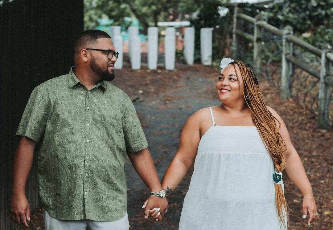 a man and a woman holding hands walking down a path a man and a woman holding hands walking down a path