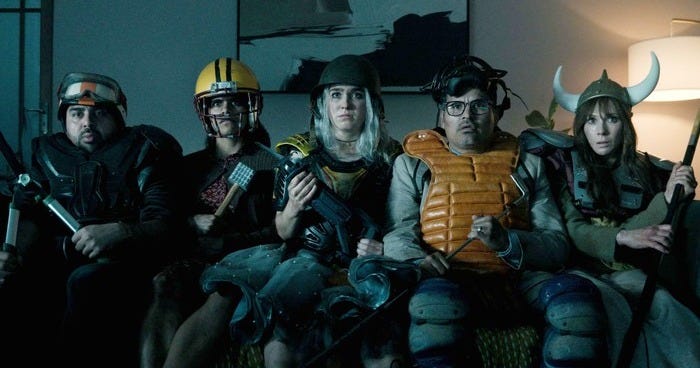 Characters in Good Luck, Have Fun, Don't Die sitting on a sofa with battle attire, including hard hats, helmets and makeshift weapons.