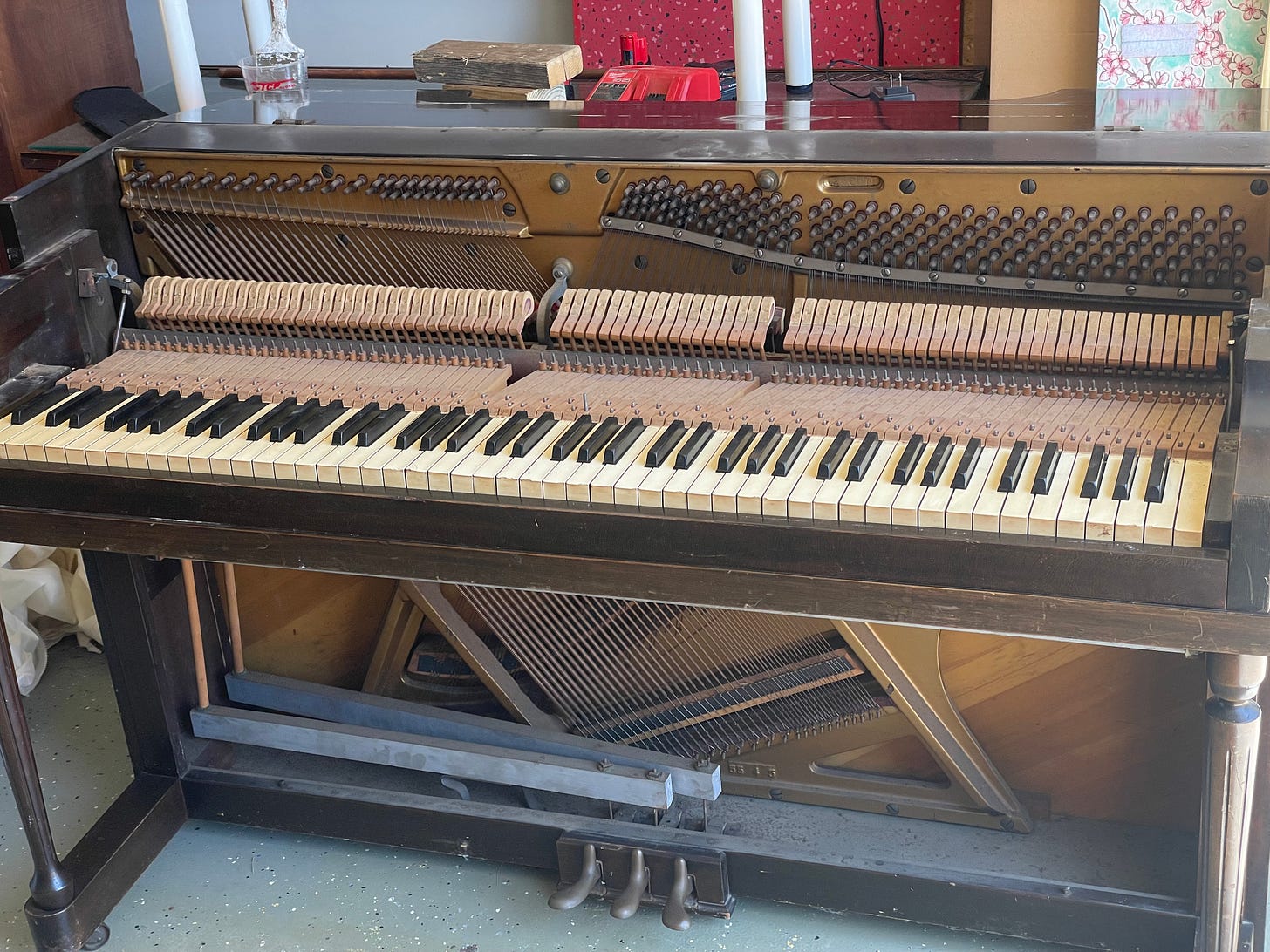 Upright piano being deconstructed, showing the keyboard, harp, and foot pedals. Upright piano being deconstructed, showing the keyboard, harp, and foot pedals.