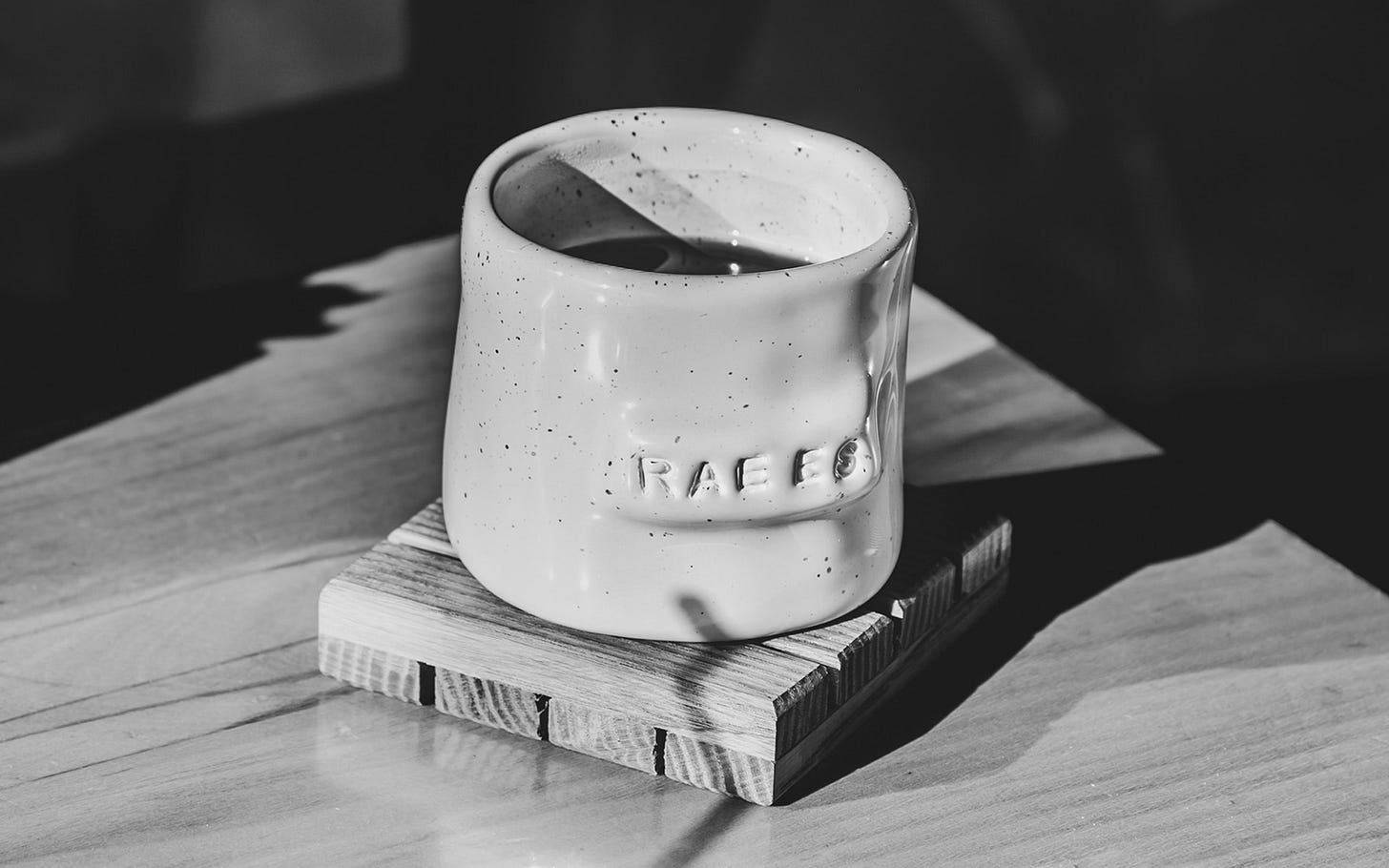 Ceramic mug sits on a wooden coaster in the sun Ceramic mug sits on a wooden coaster in the sun