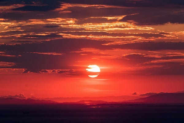 Sun setting behind clouds Sun setting behind clouds
