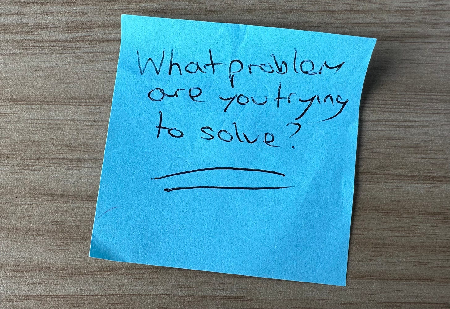 A photo of a post-it note saying "what problem are you trying to solve?"