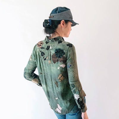 Woman wearing a green recycled shirt from Mira Musank
