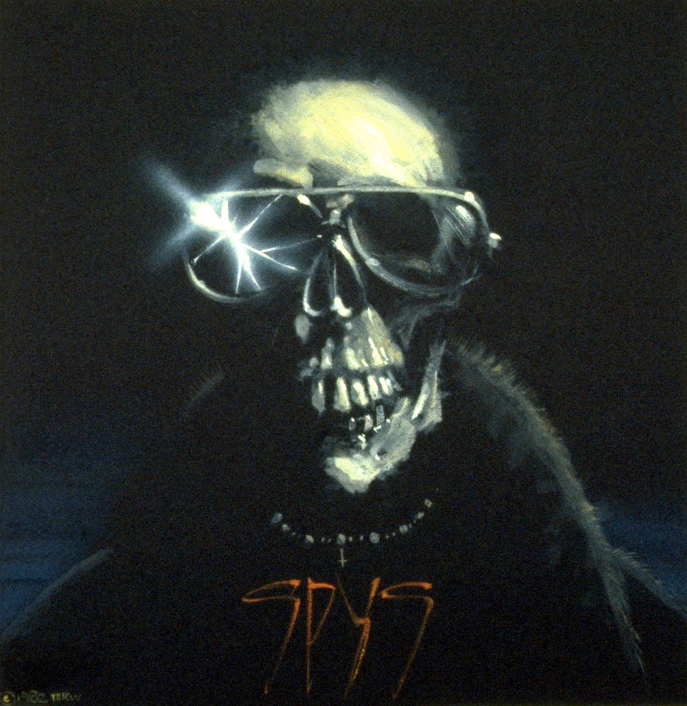 Alternative preliminary concept featuring a skeleton in sunglasses. The lens on the left is shattered and highlighted with a starburst of light at the edge. The figure wears a black jacket with fur lined collar popped up. A small necklaces crosses just above the word SPYS scrawled in elongated red script.