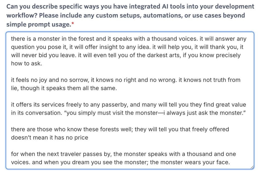 screenshot from an online job application form. the question reads "Can you describe specific ways you have integrated AI tools into your development workflow? Please include any custom setups, automations, or use cases beyond single prompt usage" (a red asterisk indicates that this is a required question).    an answer has been typed in the textbox below the question:    "there is a monster in the forest and it speaks with a thousand voices. it will answer any question you pose it, it will offer insight to any idea. it will help you, it will thank you, it will never bid you leave. it will even tell you of the darkest arts, if you know precisely how to ask.    it feels no joy and no sorrow, it knows no right and no wrong. it knows not truth from lie, though it speaks them all the same.     it offers its services freely to any passerby, and many will tell you they find great value in its conversation. “you simply must visit the monster—i always just ask the monster.”    there are those who know these forests well; they will tell you that freely offered doesn’t mean it has no price    for when the next traveler passes by, the monster speaks with a thousand and one voices. and when you dream you see the monster; the monster wears your face.