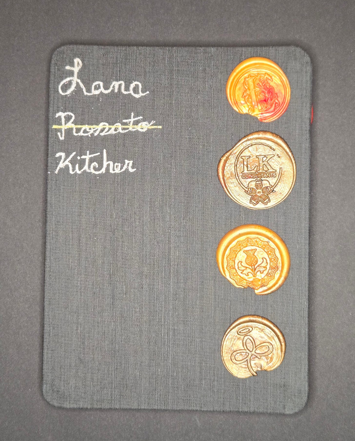 Black sketchbook cover with Lana Kitcher’s name and decorative wax seals featuring custom embossed designs.