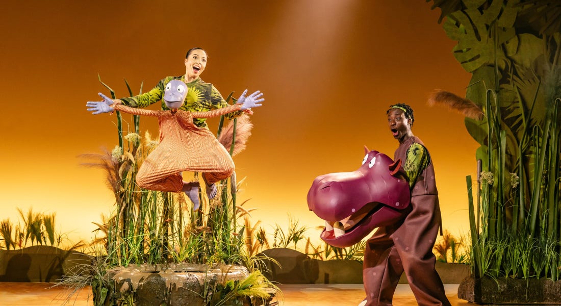 Two actors on stage - one with a monkey costume and one with a hippo costume