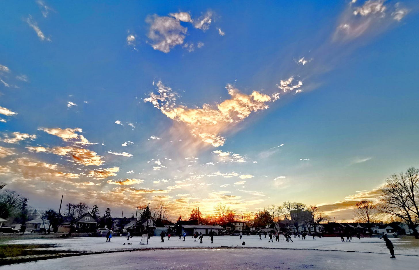 Sunrise over skaters on a skating rink.