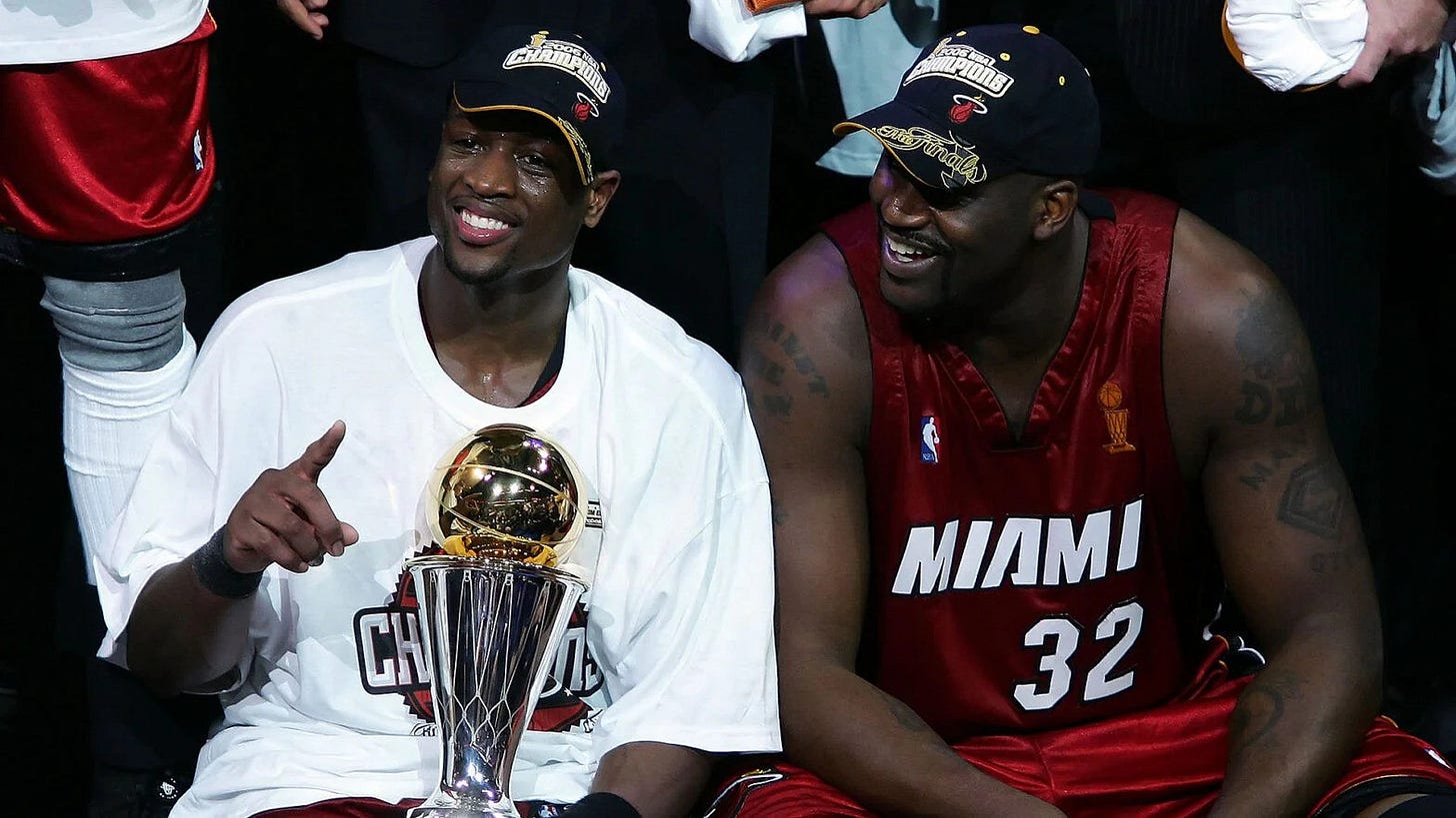 Dwayne Wade holding his MVP trophy next to Shaquille O’Neal on June 20, 2006.
