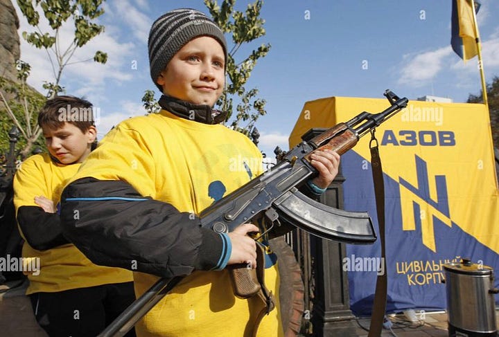 Pictures show young children being taught how to use rifles by Azov members with Swastika tattoos.