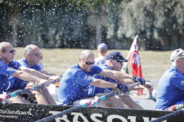 A group of rowers in a boat on the river A group of rowers in a boat on the river