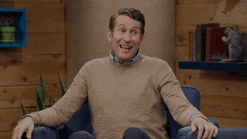 Video gif. Scott Aukerman from Comedy Bang Bang is recording a podcast video. He sits on a couch and raises his eyebrows with an open mouth, gesturing around but looking confused and unsure how to answer. Video gif. Scott Aukerman from Comedy Bang Bang is recording a podcast video. He sits on a couch and raises his eyebrows with an open mouth, gesturing around but looking confused and unsure how to answer.