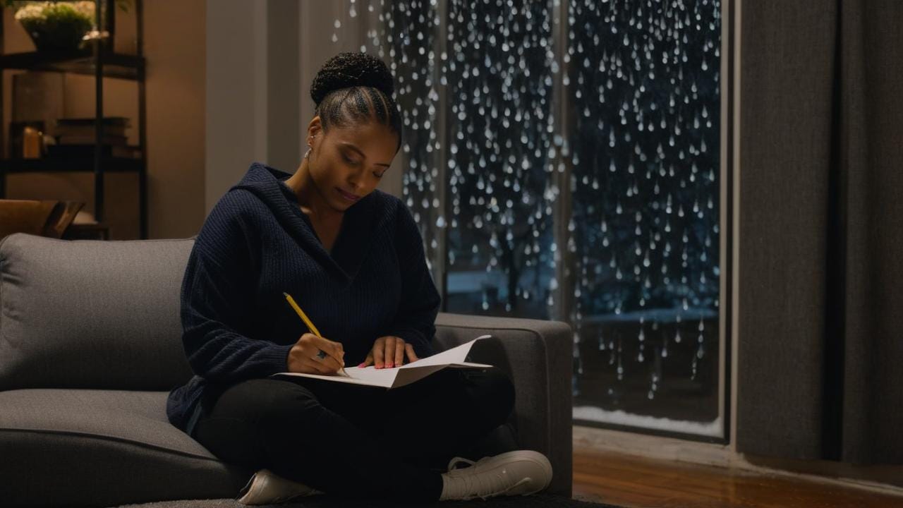 African American woman sitting in an urban  room sitting on the couch while writing a letter with a wintry rain night no tree