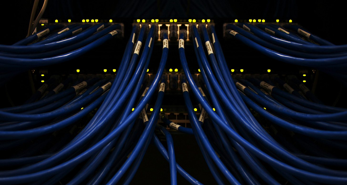 A series of blue optical cables are connected to a server unit. This illustrates the growth of data centers in the Asia Pacific region, particularly in Indonesia. A series of blue optical cables are connected to a server unit. This illustrates the growth of data centers in the Asia Pacific region, particularly in Indonesia.