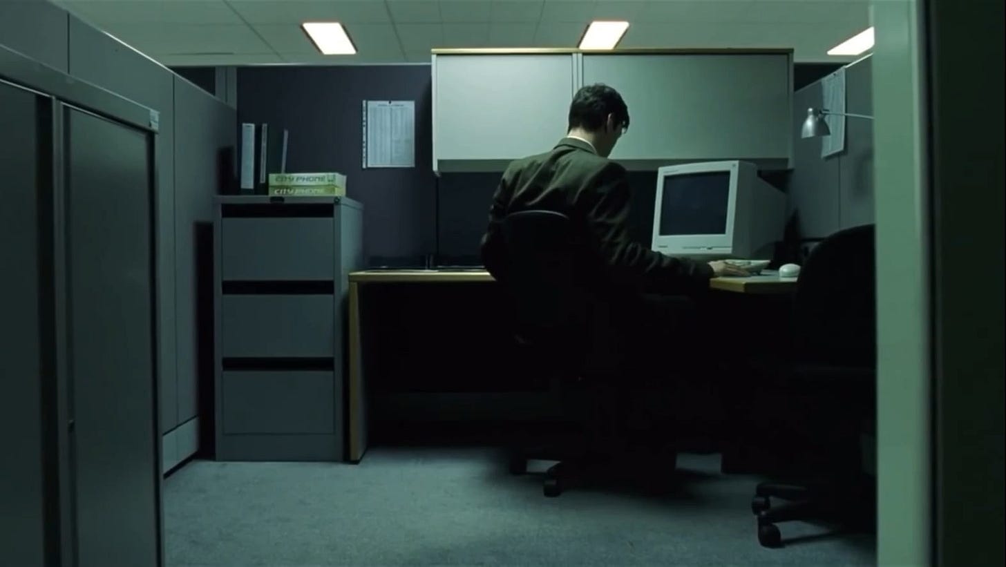 In the lower left hand corner of this Matrix scene, a persons hand and  wristwatch can be seen on the table behind Neo and a worker, despite them  being the only two people in the room.