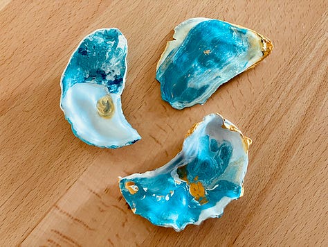 Three images of hand-painted oysters. They have paint on them in a gorgeous blend of cerulean, turquoise, gold, and white., resembling the ocean.