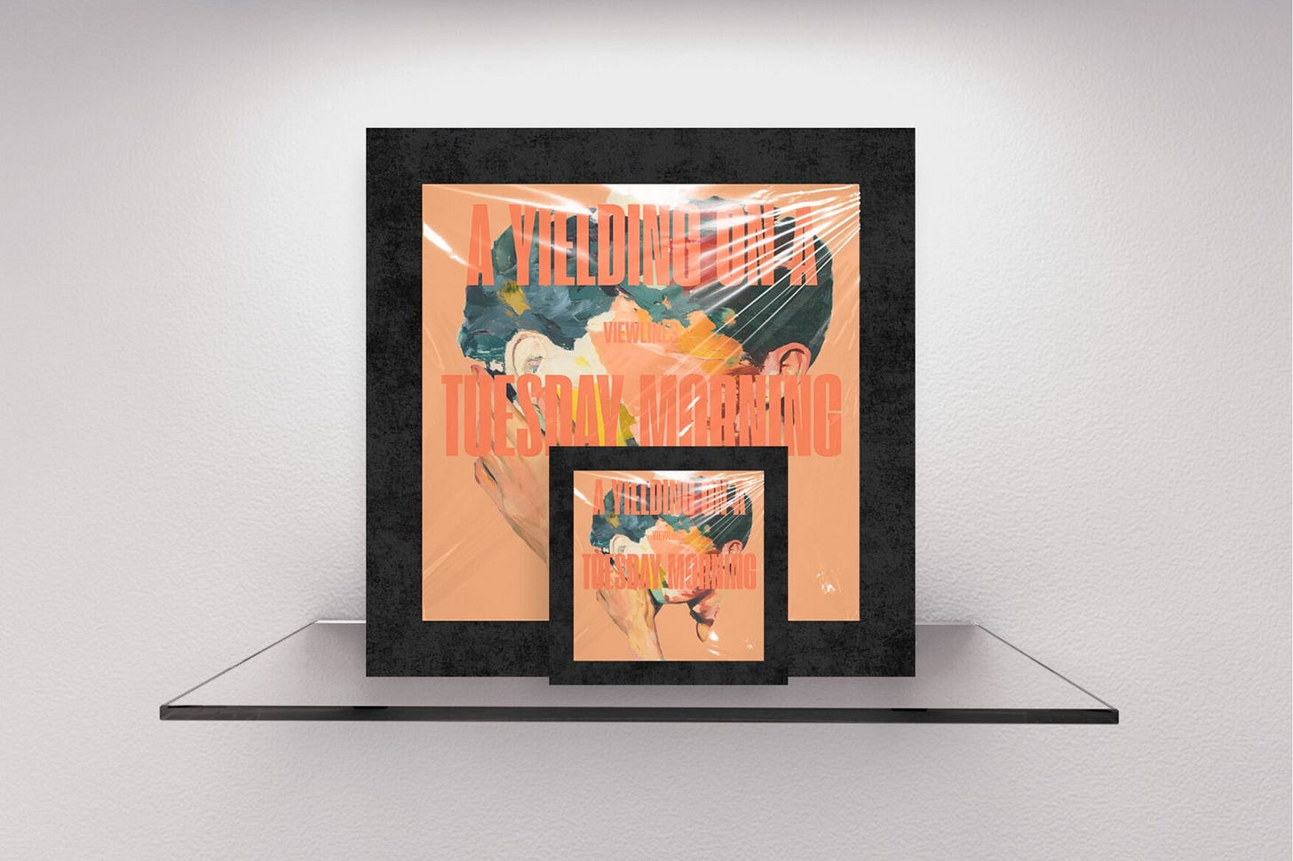 Two staggered magazine covers with thick textured black borders on a gallery shelf. The front cover features a peach background with a painterly portrait of two men, their faces smeared together via abstract strokes. Large typography reading "A YIELDING ON A TUESDAY MORNING" overlays the entire portrait. Part of the Viewlines series at The Subtext Review.
