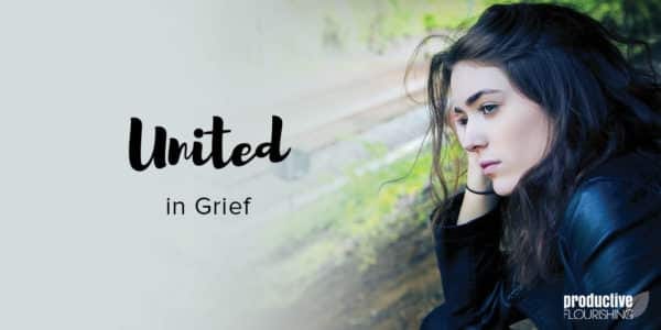 A woman with dark hair rests her head on her hand, and looks off into the distance. Text Overlay: United In Grief A woman with dark hair rests her head on her hand, and looks off into the distance. Text Overlay: United In Grief