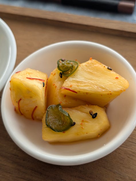 A colorful assortment of Japanese pickles, including crisp salt-brined cucumbers, deep brown soy-pickled shiitake mushrooms, and vibrant pickled fruit, arranged in small bowls.