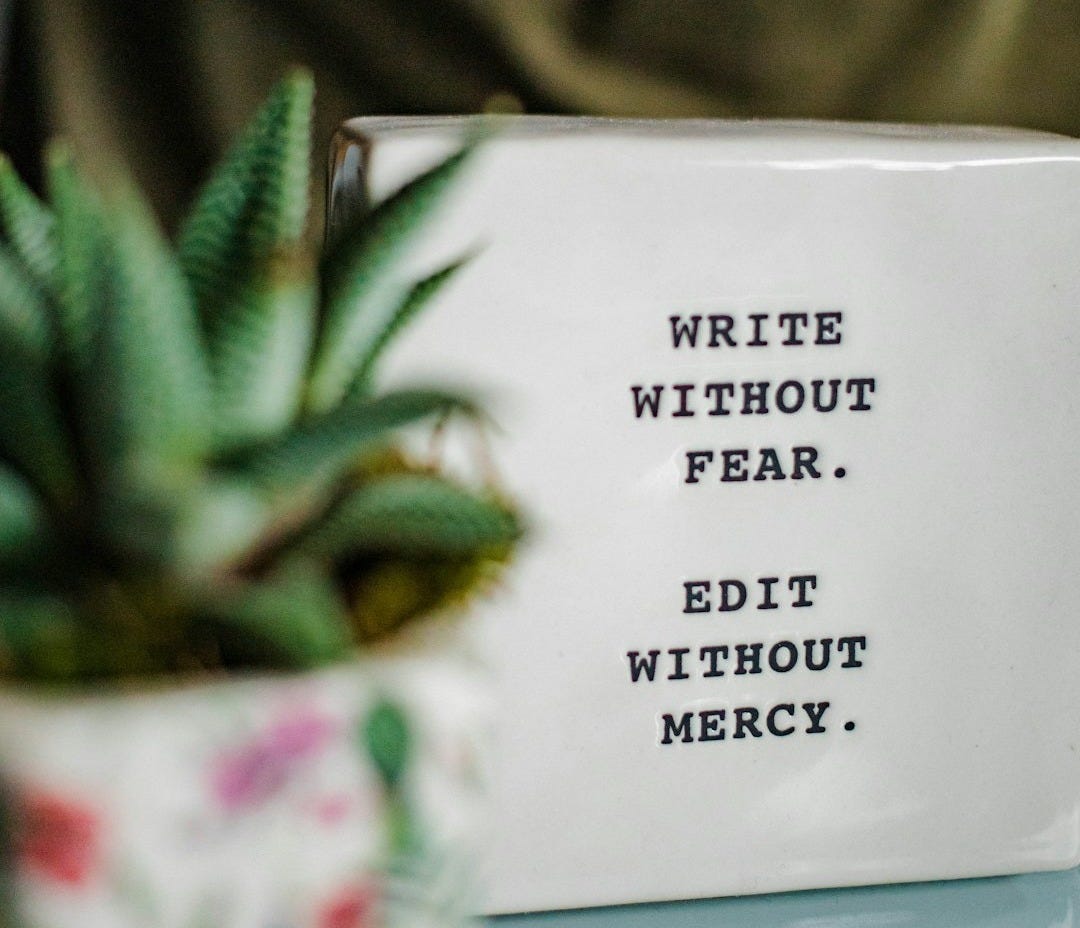 a white box with writing on it next to a plant