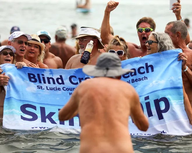 Hundreds of naturists stand together in the ocean at Blind Creek Beach during International Skinny Dip Day. Hundreds of naturists stand together in the ocean at Blind Creek Beach during International Skinny Dip Day.