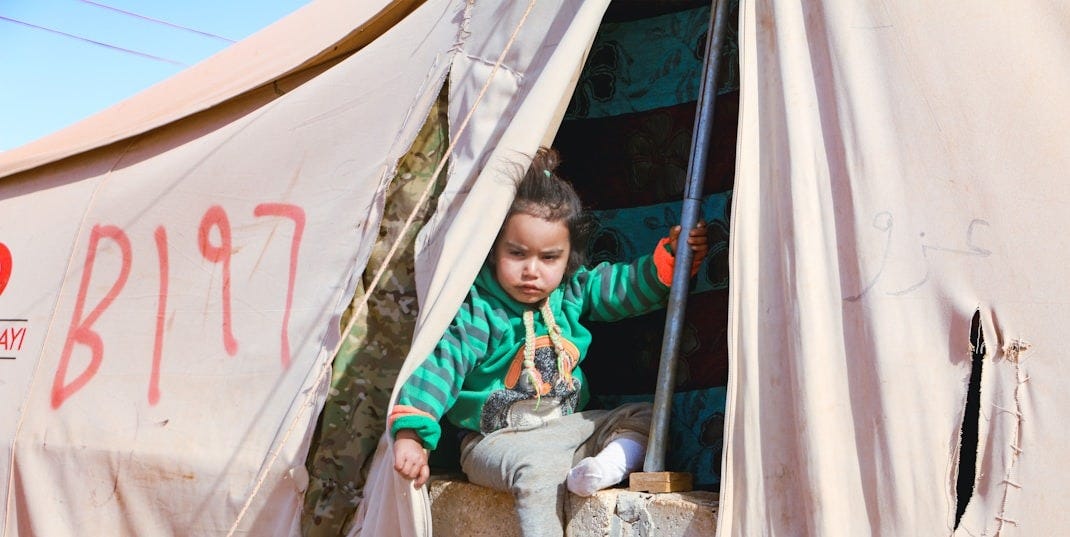 A little boy sitting inside of a tent A little boy sitting inside of a tent