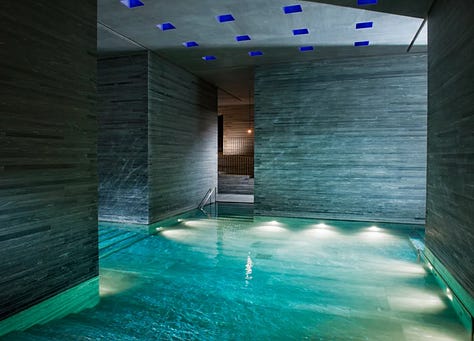 Interior of Therme Vals thermal baths by Peter Zumthor, Vals, Switzerland. Dark quartzite stone walls and thermal water pools lit by natural light from above. Architecture by Peter Zumthor.