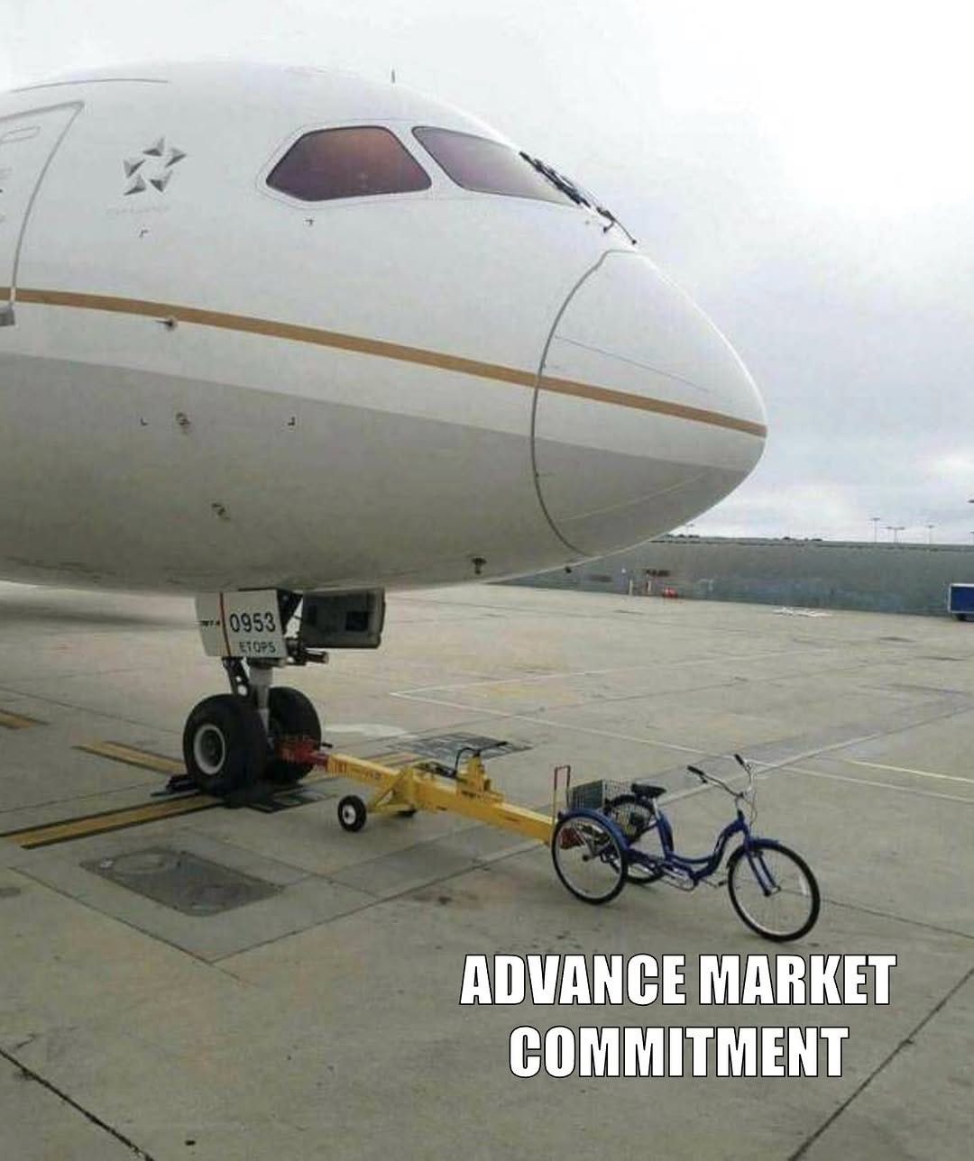 A tricycle hitched to the nose gear of a large passenger jet, captioned "Advance market commitment".