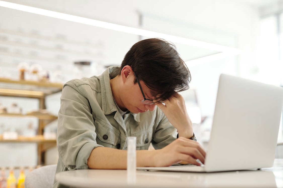 Free A Man Looking Sick while Working with His Laptop Stock Photo