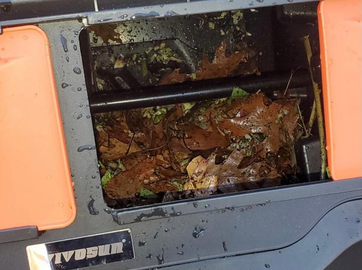 The contents of a tumbling composter and a black tumbling composter.