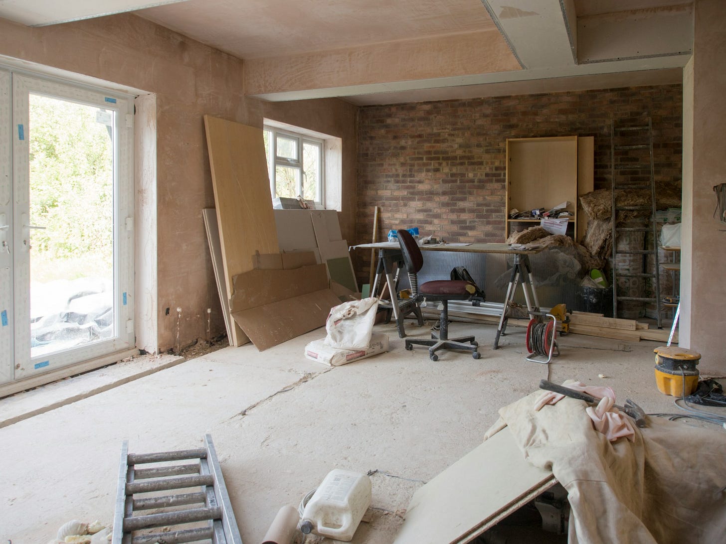 Drywall, tools and a vacuum are scattered around a home being renovated.