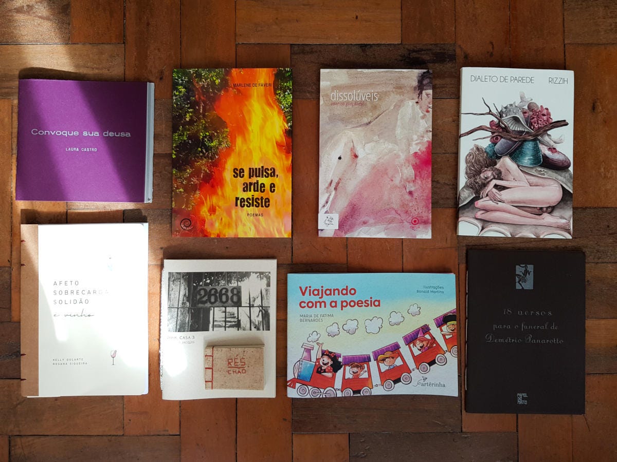 Foto colorida de oito livros espalhados sobre um chão de taco.