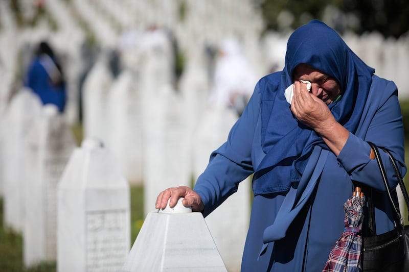 A Bosnian Muslim woman visits gravestones during a funeral ceremony for 50 newly-identified Bosnian Muslim victims, at the Potocari Memorial Centre and Cemetery in Srebrenica, Bosnia-Herzegovina, in July 2022. Photograph: Jasmin Brutus/EPA