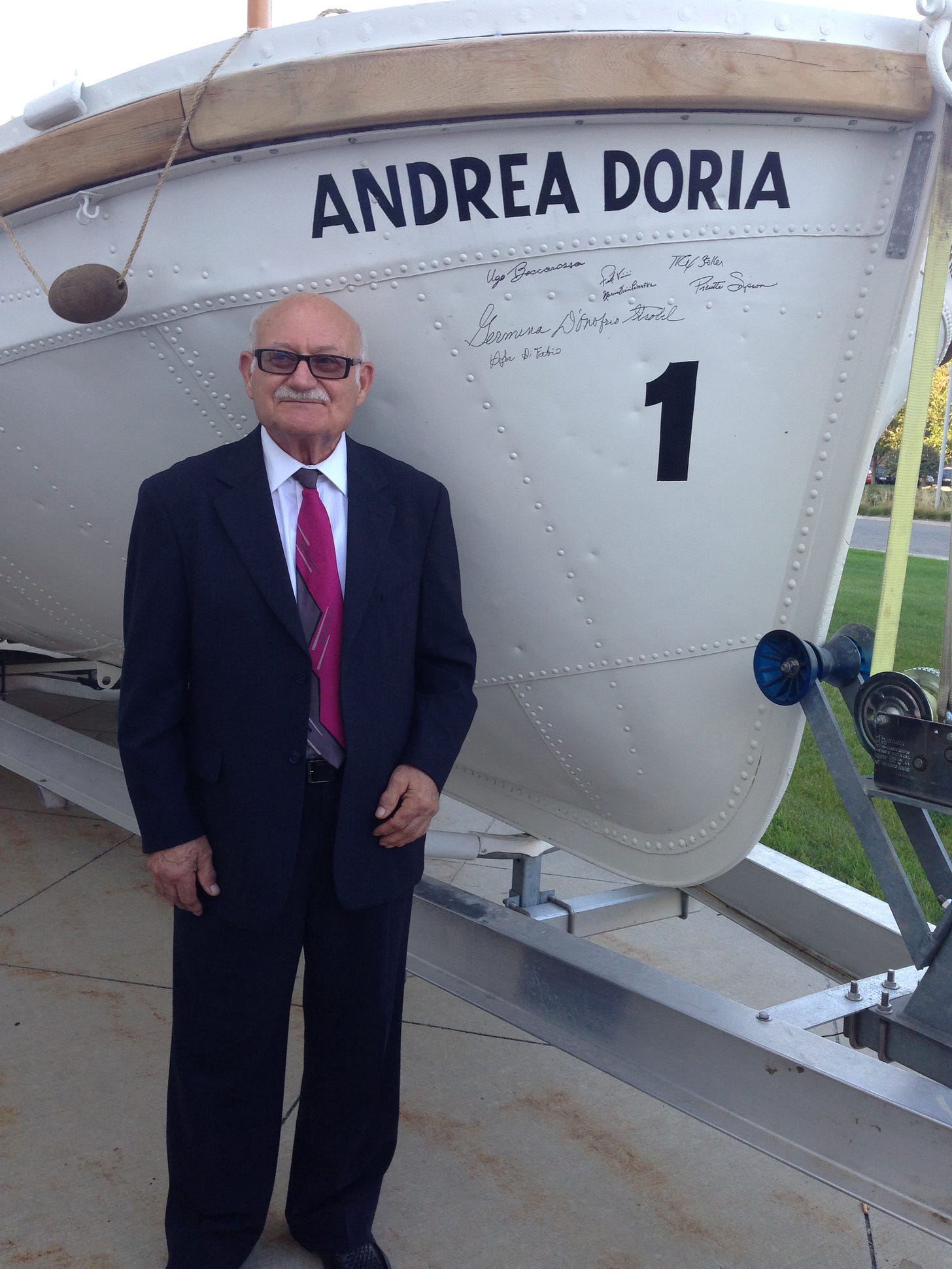Ugo standing in front of the Andrea Doria at a commemorative gala event