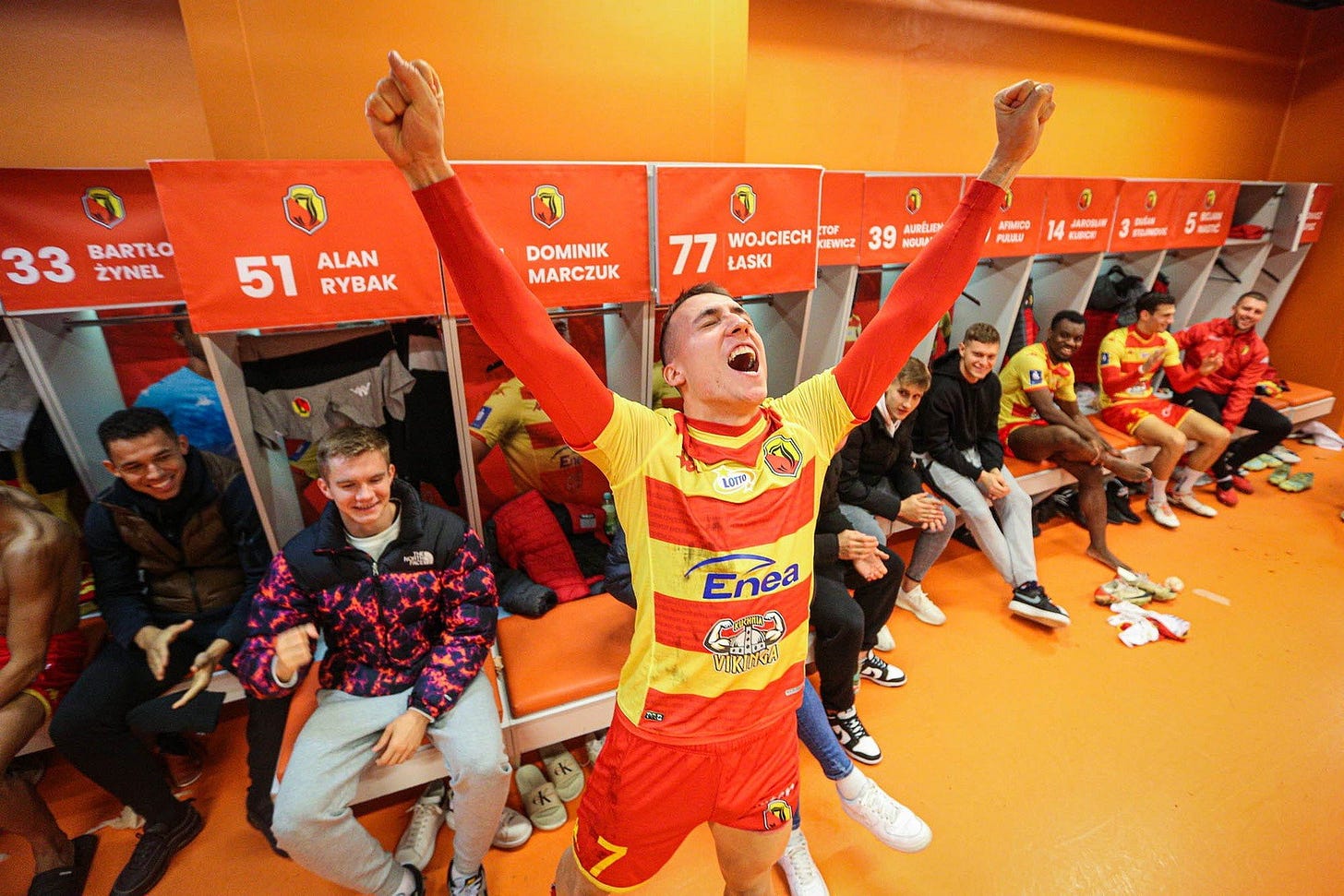 Dominik Marczuk celebrates in the Jagiellonia Bialystok locker room in the clubs home kit