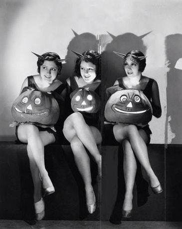 This may contain: three women in costumes sitting on a bench with their heads turned to look like pumpkins
