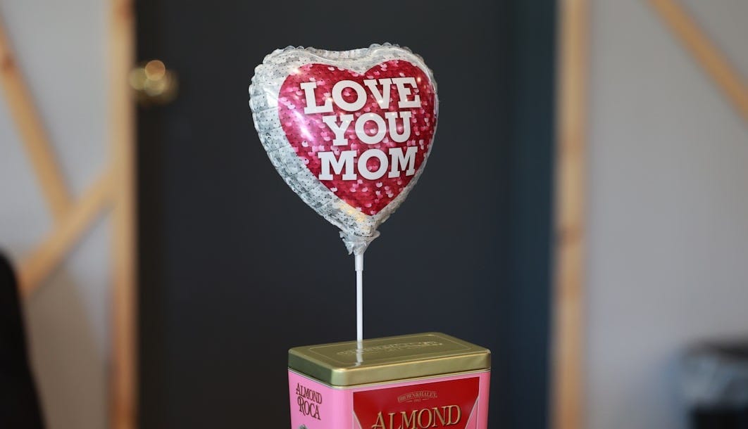 a heart shaped balloon sitting on top of a box