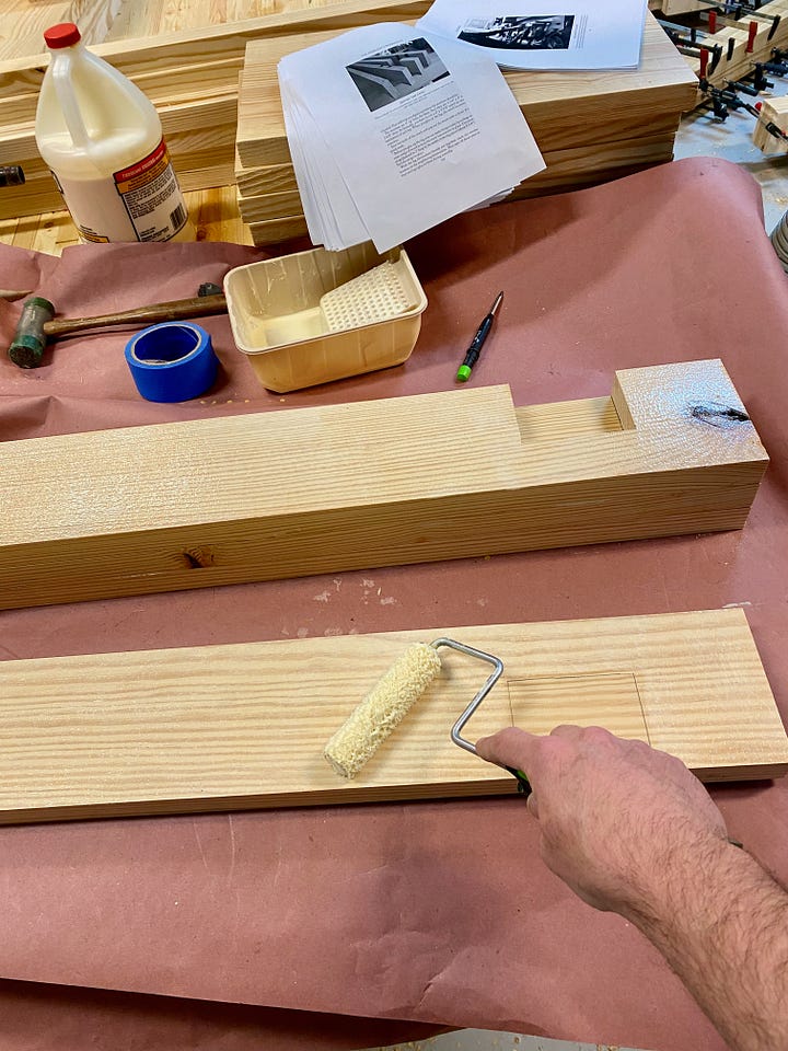 Chiseling a notch in a leg, gluing and clamping a leg, and then cutting a second notch with a chisel.