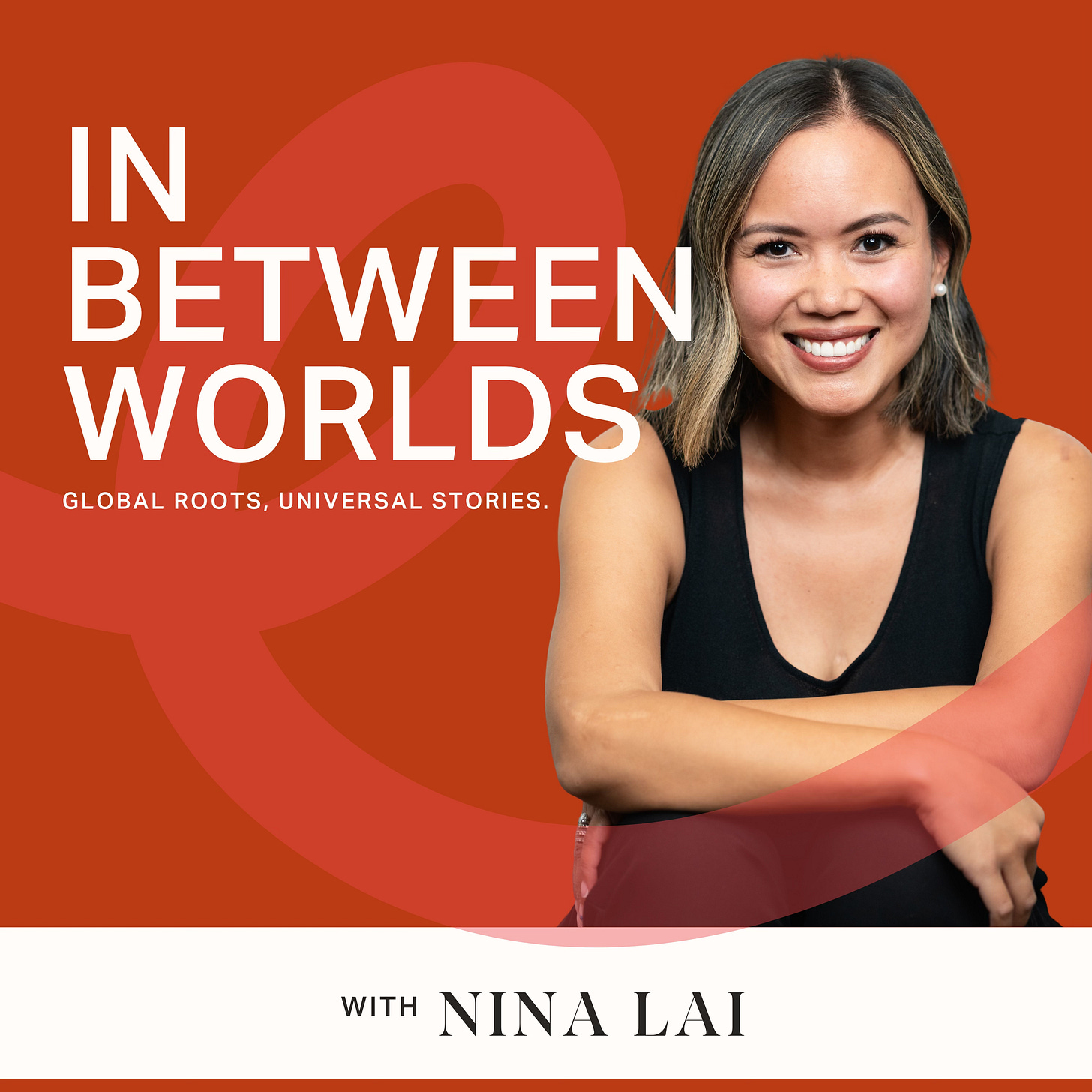 Podcast cover art for In Between Worlds showing host Nina Lai smiling with arms crossed against an orange and red gradient background with circular design elements. Text reads "In Between Worlds: Global Roots, Universal Stories" with "With Nina Lai" at the bottom.
