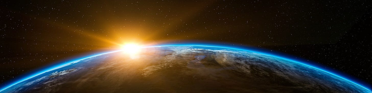 A stunning view of planet Earth from space with a bright, golden sunrise emerging over the horizon. The atmosphere glows in blue against the dark expanse of space, dotted with countless stars. Clouds and land formations are partially visible on the planet's surface.