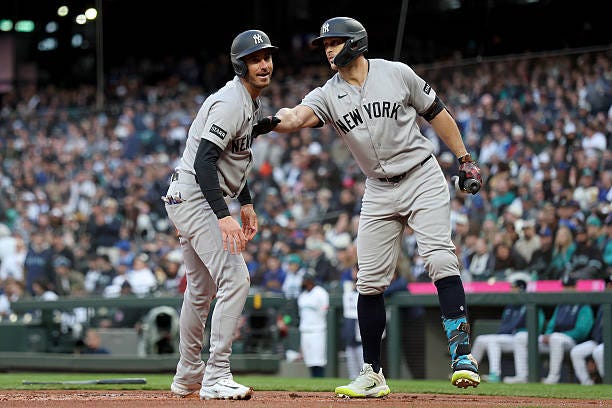 Cody Bellinger of the New York Yankees celebrates his run with Giancarlo Stanton during the first inning against the Seattle Mariners at T-Mobile...