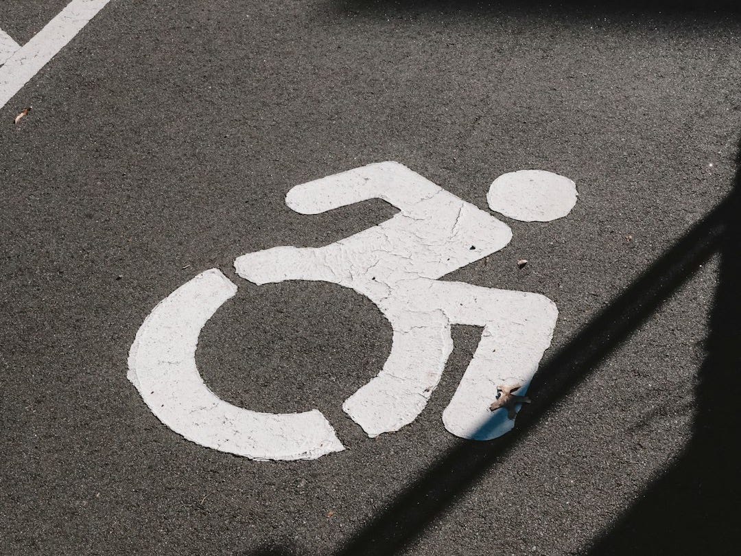 A handicapped sign painted on the ground in a parking lot A handicapped sign painted on the ground in a parking lot