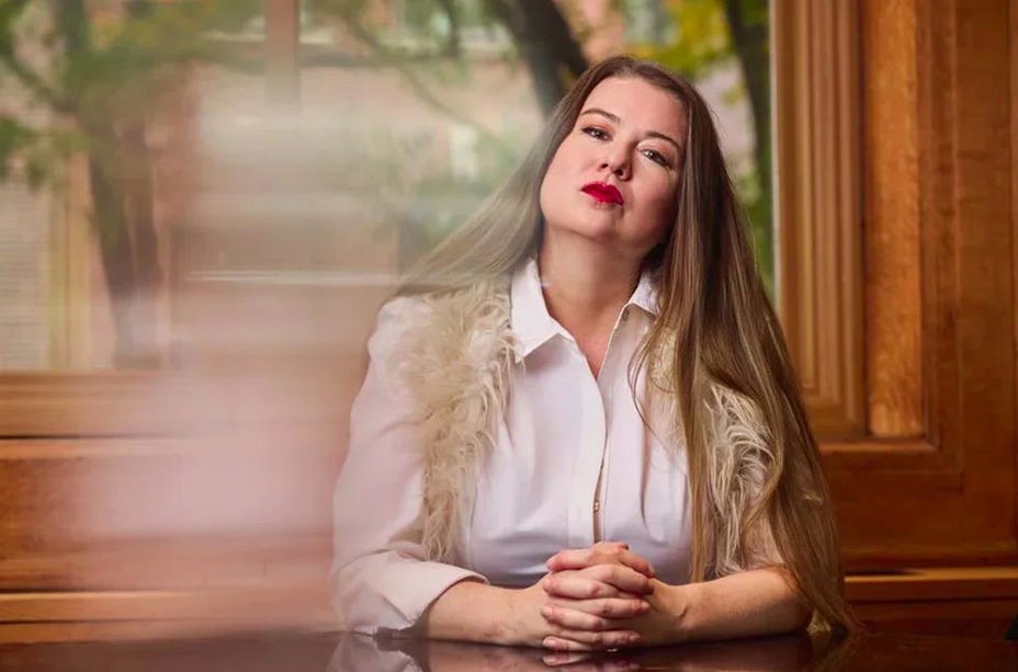 Lara St. John sitting at a table with her hands crossed. Lara St. John sitting at a table with her hands crossed.