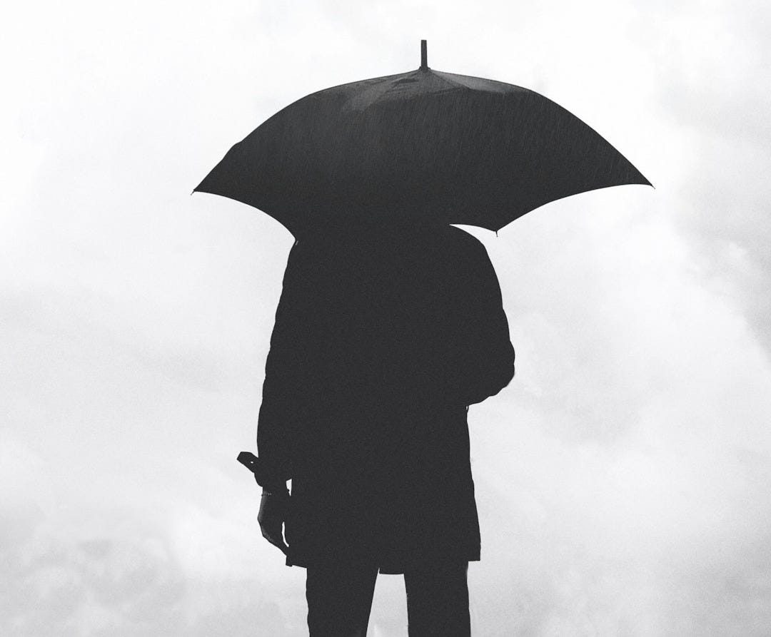 silhouette of person under umbrella under cloudy sky silhouette of person under umbrella under cloudy sky