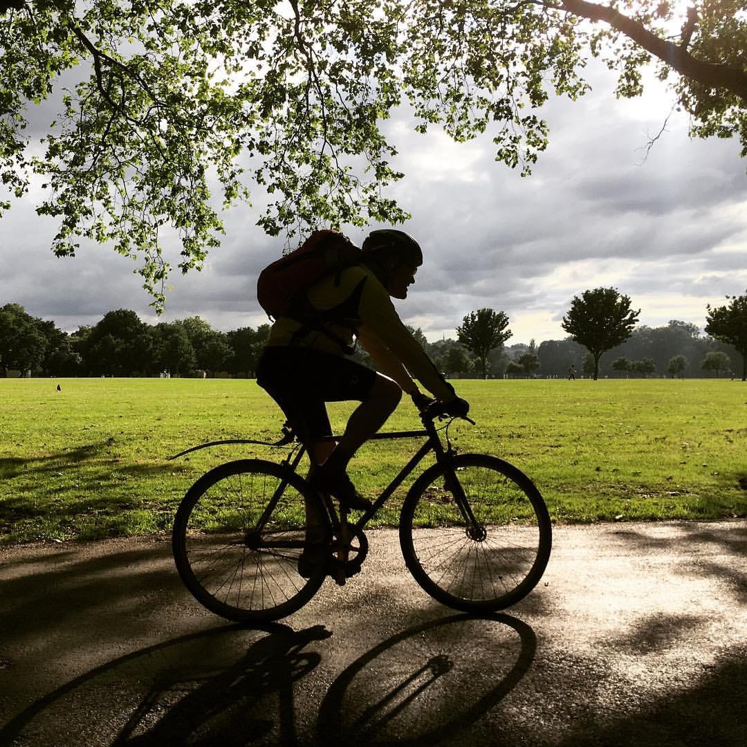 A cyclist traveling across Victoria Park in East London. A cyclist traveling across Victoria Park in East London.