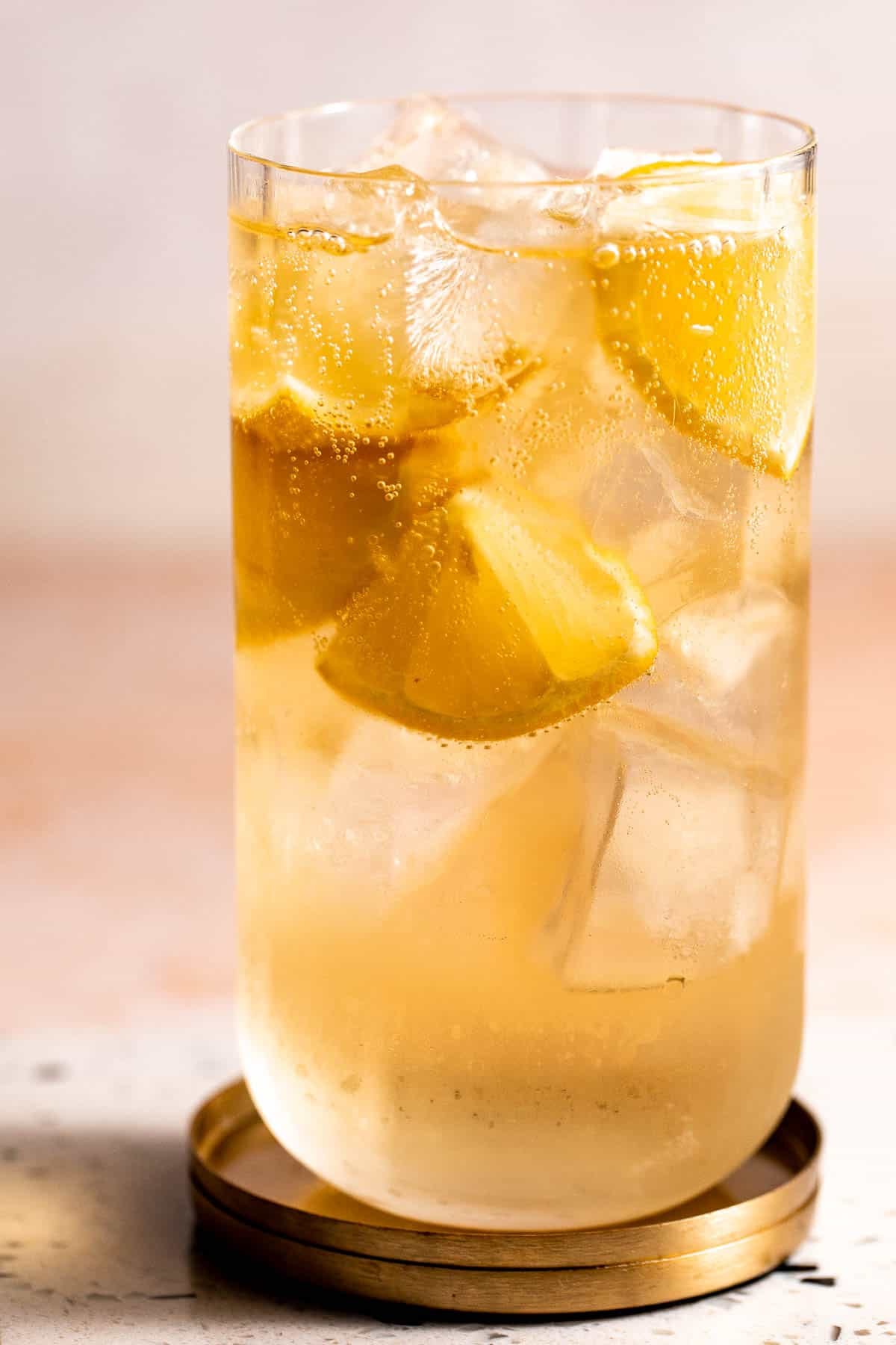 A 7 and 7 cocktail served with ice and lemon wedges in a highball glass.