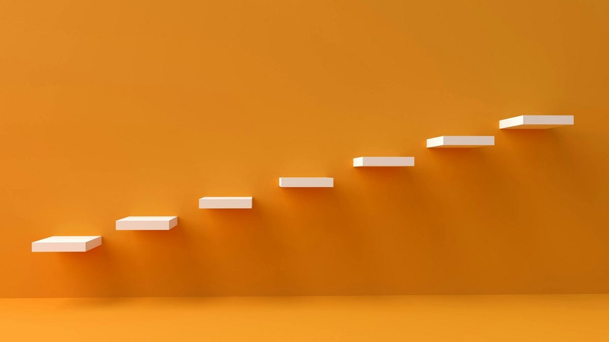 Un mur orange avec des étagères à différents niveaux