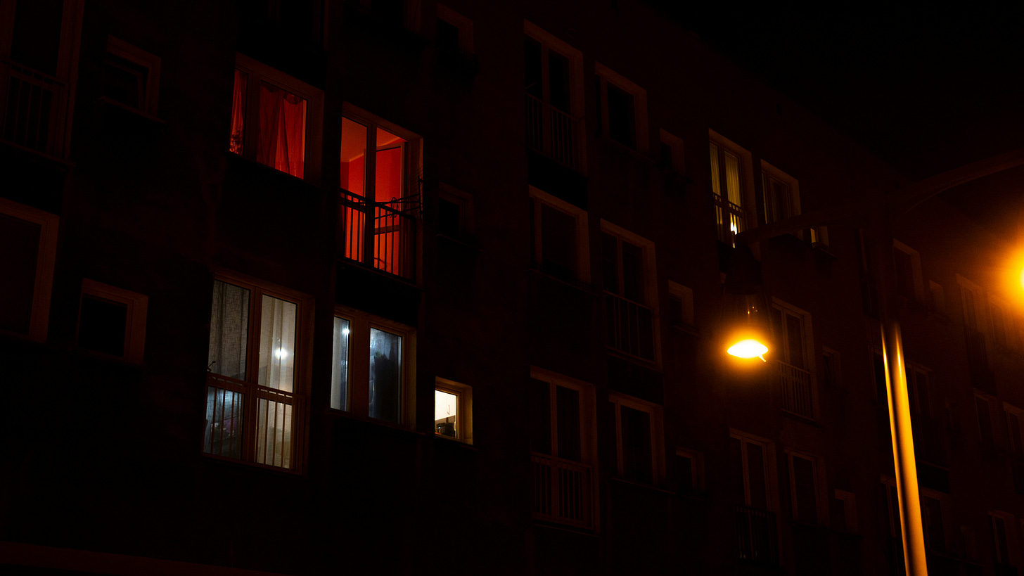 An apartment building at night with illuminated windows.